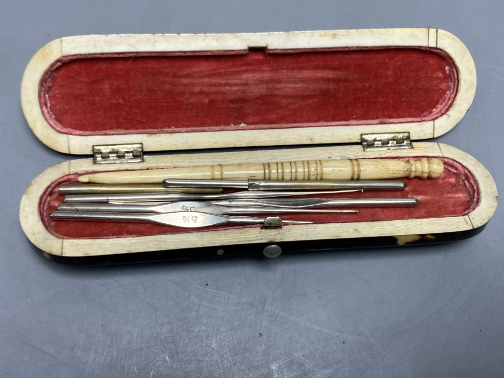 A 19th century papier mache faux tortoiseshell snuff box and a tortoiseshell case containing lace bobbin and needles